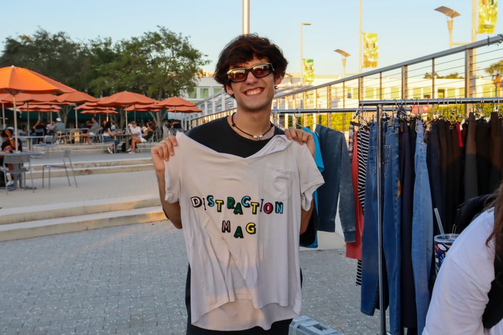 Andrew McCleskey poses with the Distraction Magazine shirt he made at the crafting tables at the UThirft Fashion Show at the Lakeside Patio on Oct 26.