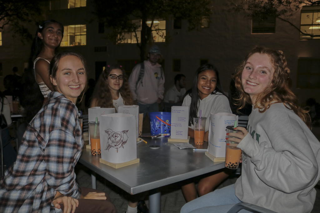 Students sit around a table and enjoy boba at the 2022 Lantern Festival presented by the Asian American Student Association on Oct. 21 in the architecture courtyard.