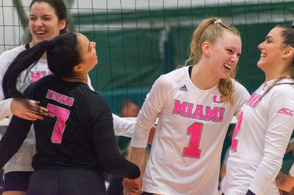 Senior setter Savannah Vach laughs with teammates during Miami's pink match against Duke on Sunday, Oct. 9 in the Knight Sports Complex.