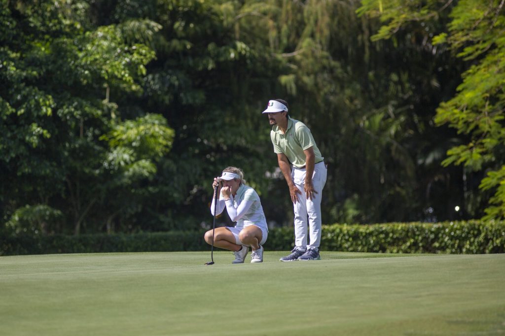 Third-year sophomore Sara Byrne prepares to putt as assistant coach Marcelo Huarte offers advice on day one of Miami’s Hurricane Invitational at the Biltmore Hotel on Monday, Oct. 31.