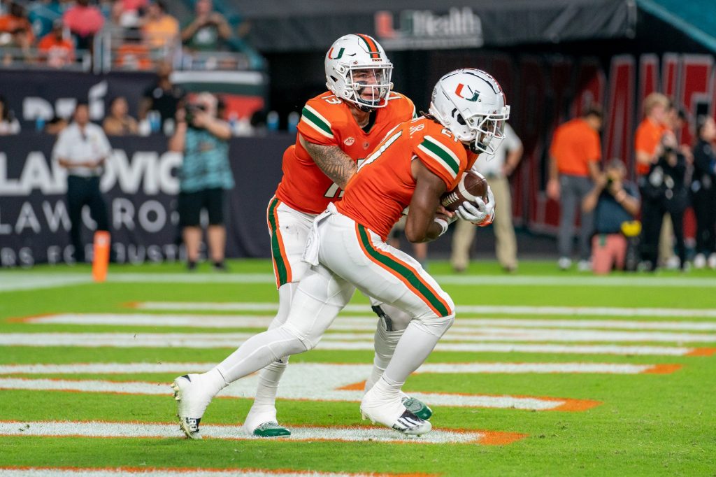 Redshirt freshman quarterback Jake Garcia hands the ball off to third-year sophomore running back Henry Parrish, Jr. during the first quarter of Miami’s game versus the University of Pittsburgh at Hard Rock Stadium on Nov. 26, 2022.