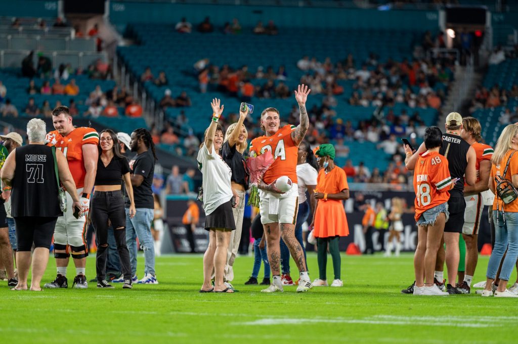 Sixth-year redshirt senior punter Lou Hedley waves to the stands with his family duiring senior night on Saturday, Nov. 26 at Hard Rock Stadium.