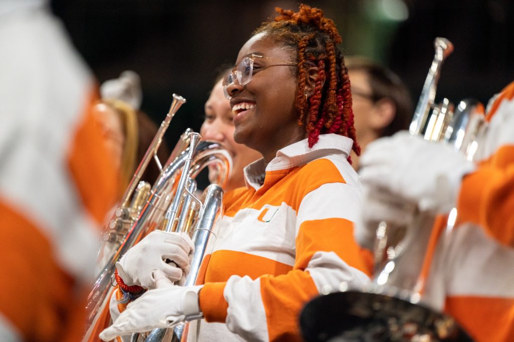 Junior Ava Harris watches the Frost Band of the Hour Drumline perform during halftime of Miami's game against the University of Michigan on Thursday, Dec. 1 at the Watsco Center.
