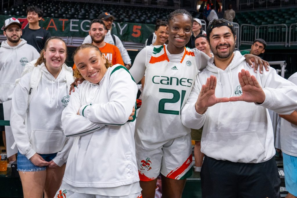 Seniors Kenza Salgues and Lola Pendande pose with student fans after Miami’s 85-74 win over the University of Virginia in the Watsco Center on Feb. 26, 2023.