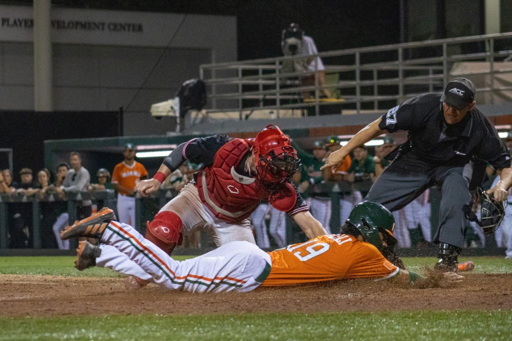 Junior infielder Dominic Pitelli slides into home plate attempting to beat the ball there after CJ Kayfus hits it to the outfield against North Carolina State on March 11.
