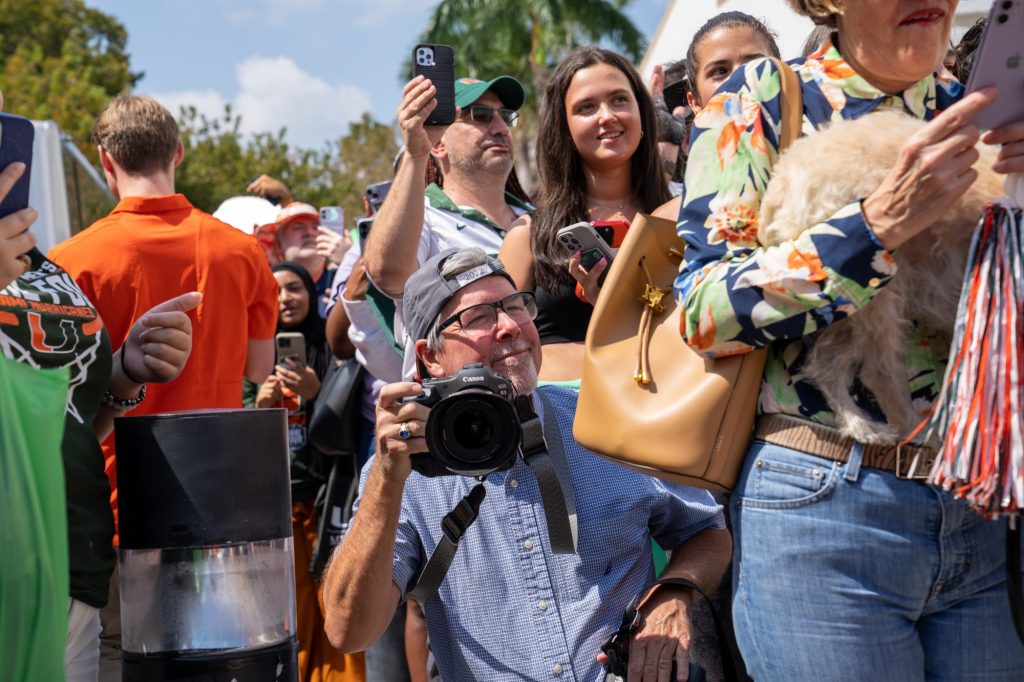 Miami Herald photojournalist Al Diaz captures the scene outside of the Watsco Center during The Miami Final Four Sendoff on March 29, 2023.