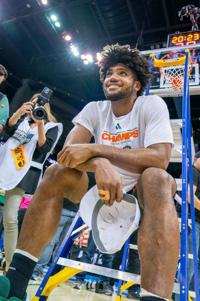 Third-year sophomore forward Norchad Omier sits on a ladder under the basket and smiles after Miami’s 88-81 Elite Eight win over the University of Texas in the T-Mobile Center in Kansas City, MO on March 26, 2023.