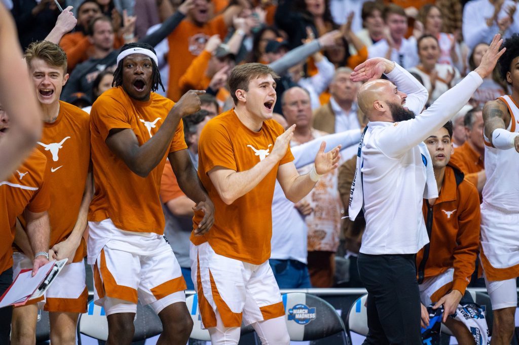 The Texas bench celebrates a three-point shot during the first half of Miami's Elite Eight win on Sunday, March 26 at the T-Mobile Center.