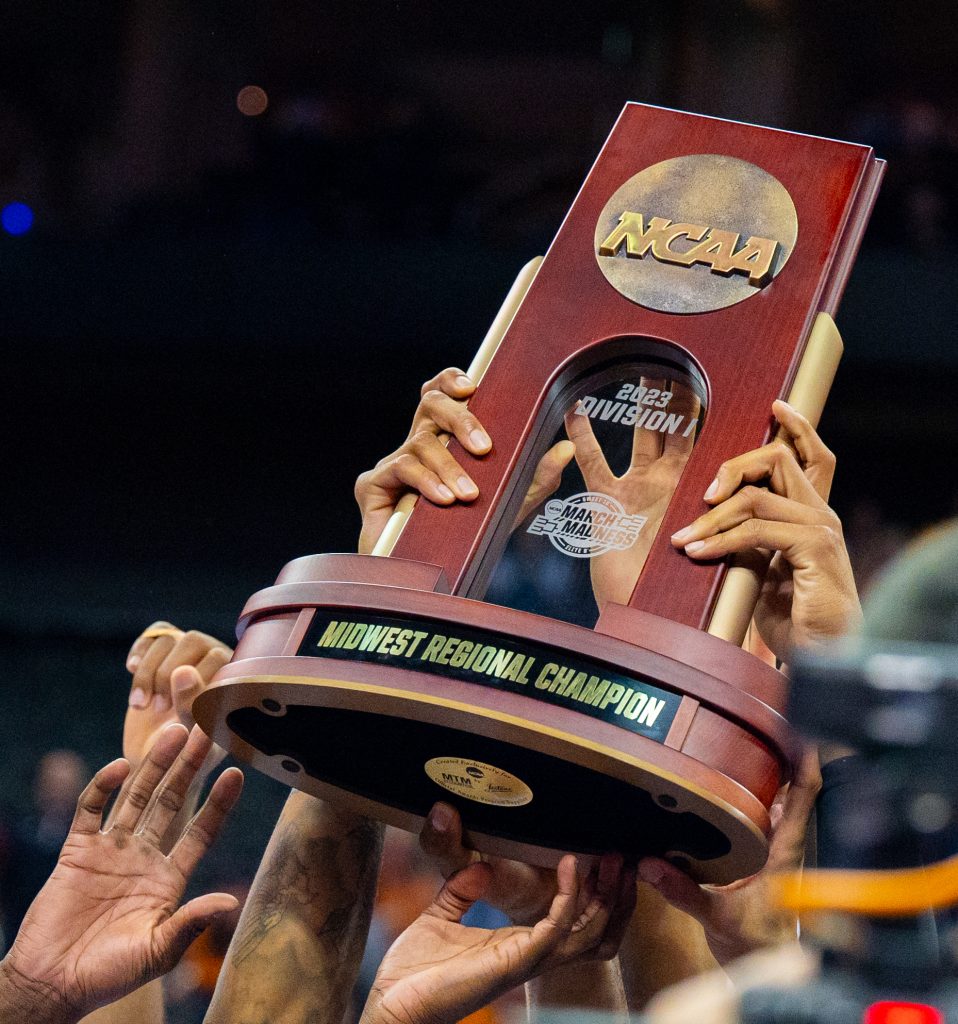The 'Canes hold up the Midwest Regional Champion trophey following Miami's win over the University of Texas on Sunday, March 26 at the T-Mobile Center.