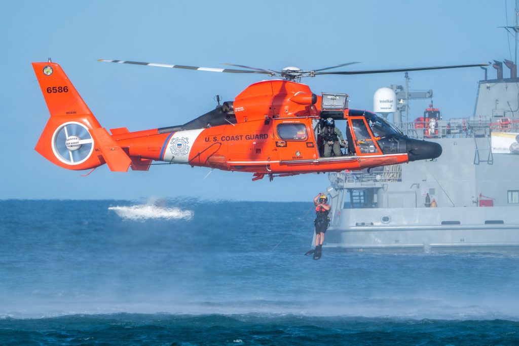 A U.S. Coast Guard swimmer jumps into the water from an MH-65 Dolphin Helicopter at the Hyundai Air and Sea Show at Miami Beach on May 27, 2023.