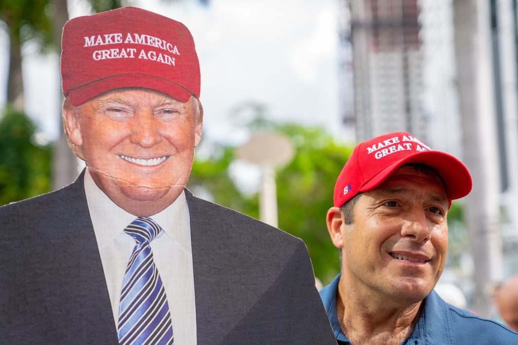 A Trump supporter smiles next to his cardboard cutout outside of the Wilkie D. Ferguson Jr. United States Courthouse ahead of Former President Trump’s indictment on June 13, 2023.