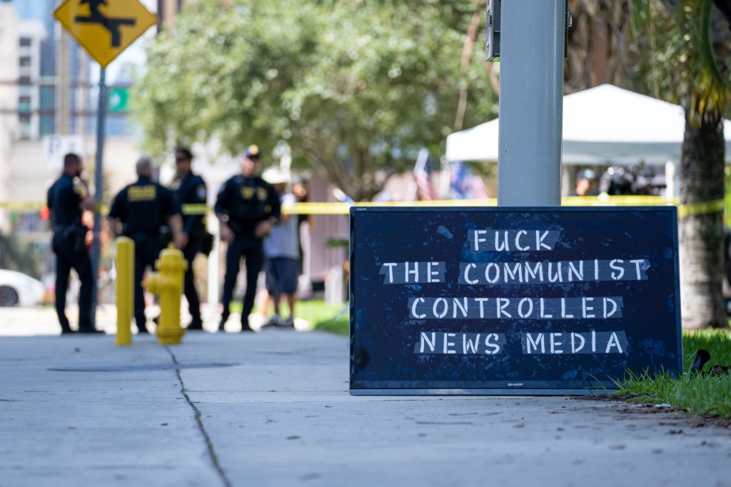 A television displaying an anti-media message sits propped up against the pole it was removed from outside of the Wilkie D. Ferguson Jr. United States Courthouse on June 13, 2023.