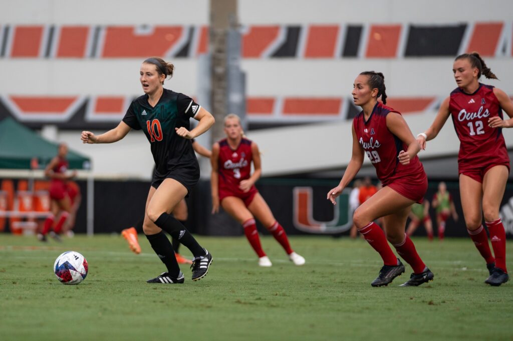 Senior midfielder Julia Edwards dribbles the ball away from defenders during the first half of Miami’s match versus FAU at Cobb Stadium on Aug. 20, 2023.