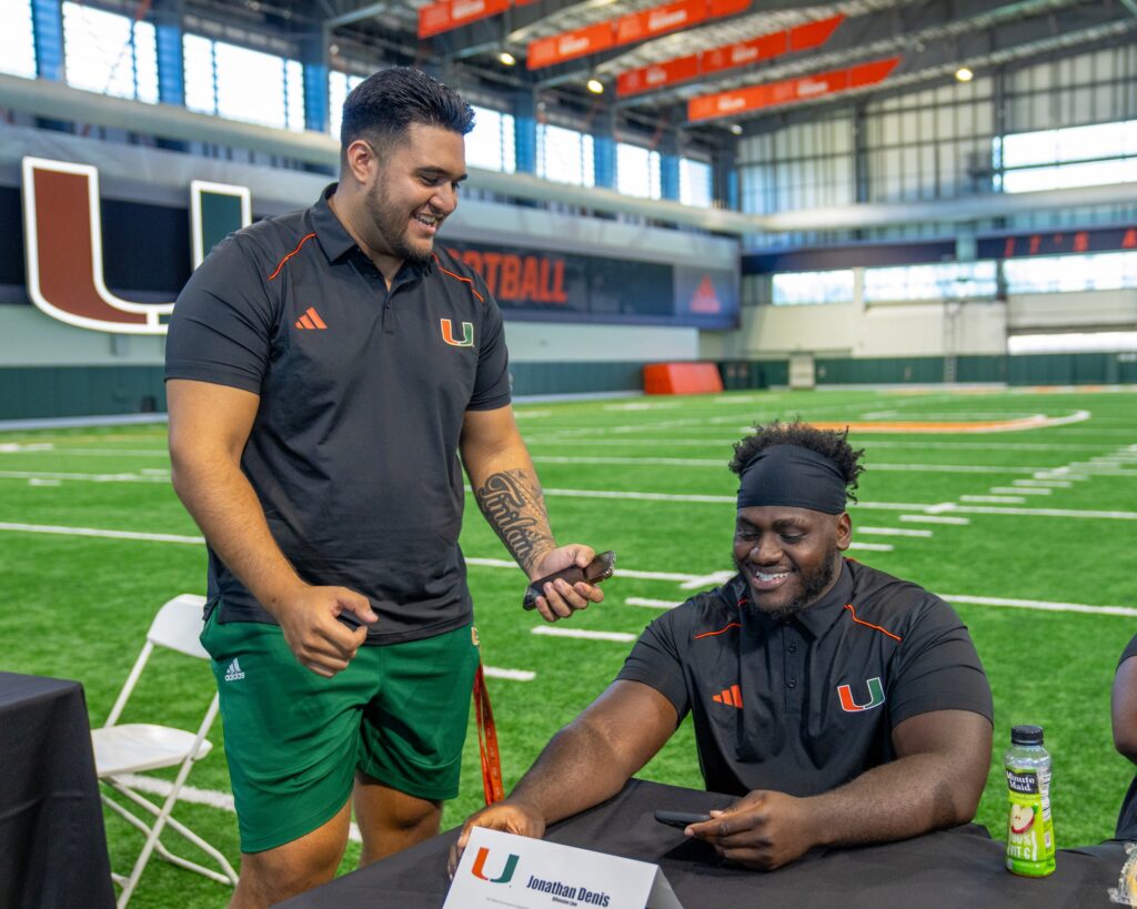 Freshman offensive tackle Frankie Tinilau interviews fourth-year redshirt sophomore offensive lineman Jonathan Denis during Media Day in the Carol Soffer Indoor Practice Facility on July 31, 2023.