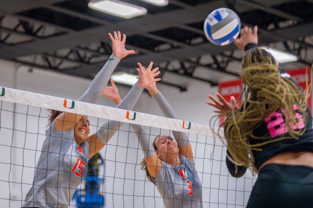 Junior outside hitter Nyah Anderson and sophomore outside hitter Gianna Tejada reach to block a spike during the fourth set of Miami’s match versus Florida Atlantic University in the Knight Sports Complex on Aug. 28, 2023.