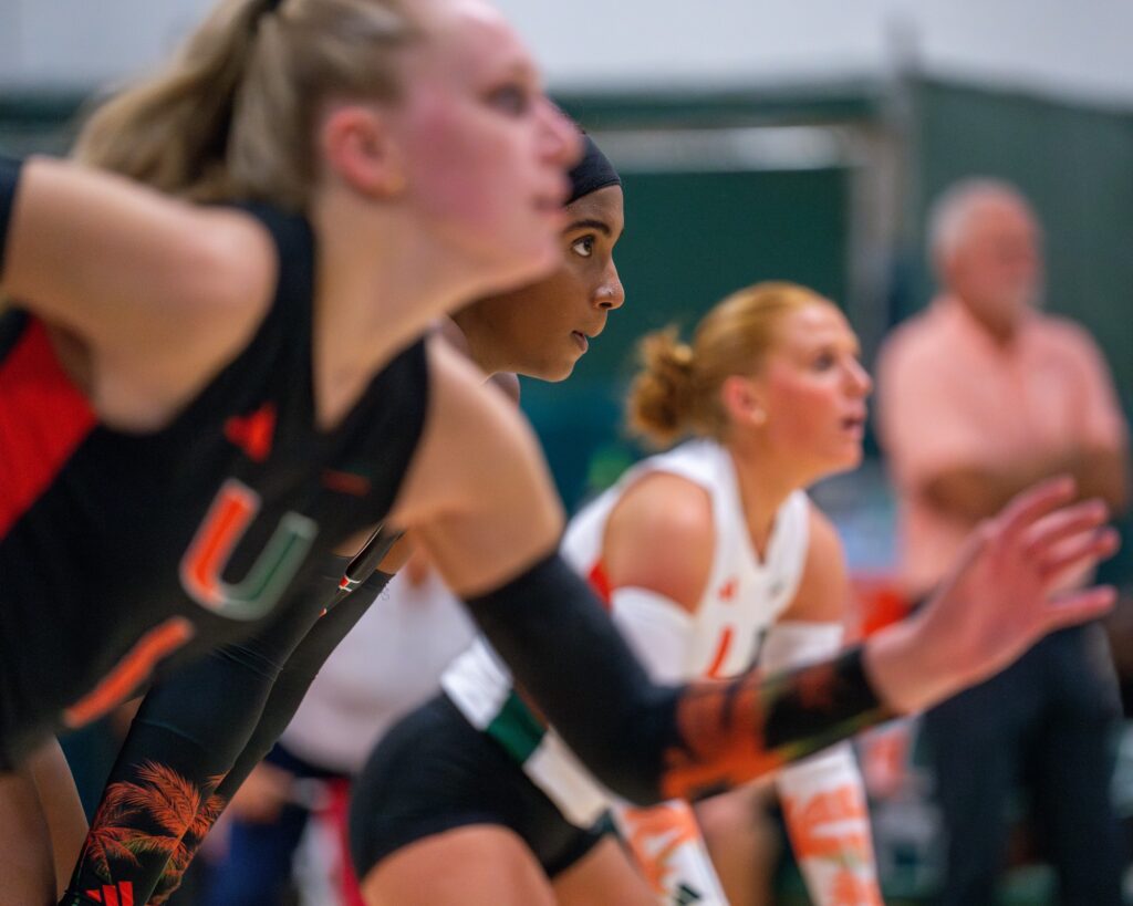 ‘Canes players wait for the serve during the fourth set of Miami’s match versus Maryland in the Knight Sports Complex on Aug. 25, 2023.
