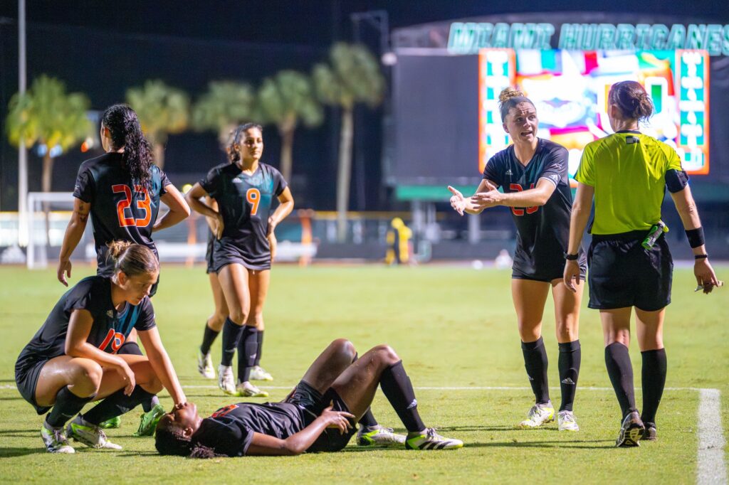 Graduate student defender Emma Tucker makes her case for a ‘Canes penalty with an official after teammate graduate student defender Taylor Shell was involved in a collision in the penalty area in the final minutes of Miami’s game versus Florida Atlantic University at Cobb Stadium on Aug. 20, 2023.