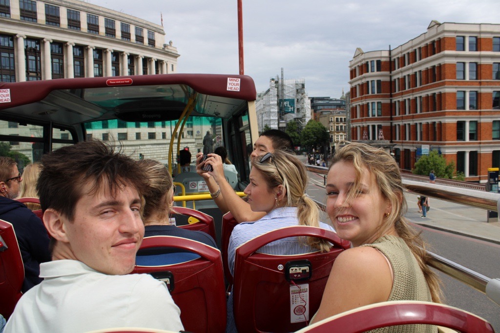Students ride a double decker bus through the streets of London.
