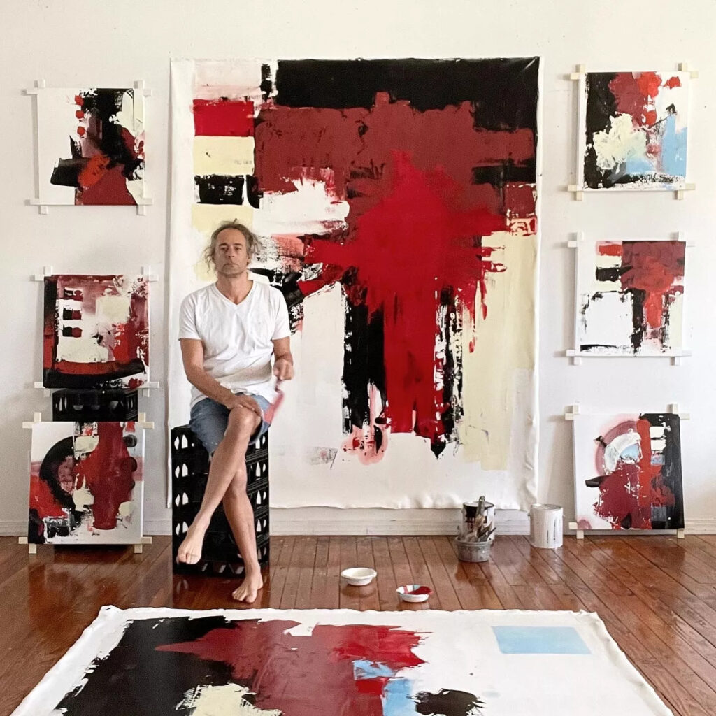 Miami artist Jordan Betten poses next to his piece “Primal Air” painted with oil on canvas.