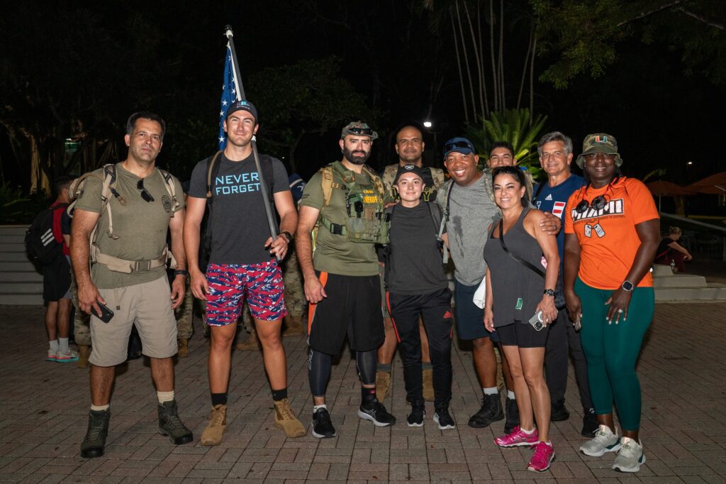 Members of law enforcement, the military, and senior Alex Westover pose for a photo before the start of the fourth annual UM Ruck to Remember on Sept. 11, 2023.
