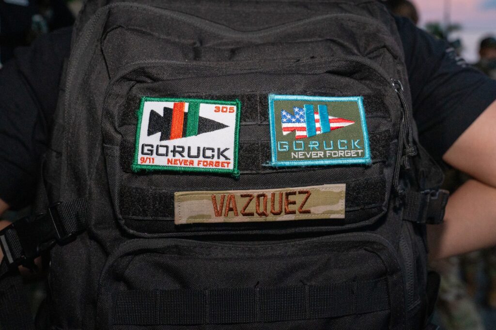 A participant displays previous UM Ruck To Remember patches on his pack while marching towards Tropical Park, during the first leg of the fourth annual UM Ruck to Remember in the early morning of Sept. 11, 2023.