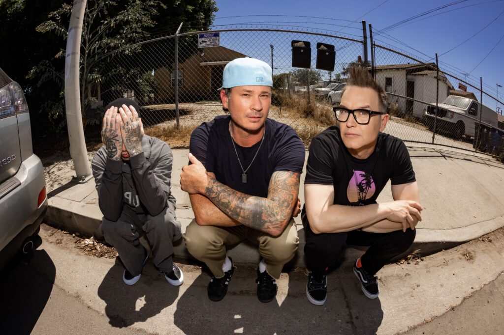 Blink-182 members Mark Hoppus, Tom DeLonge and Travis Barker pose together.