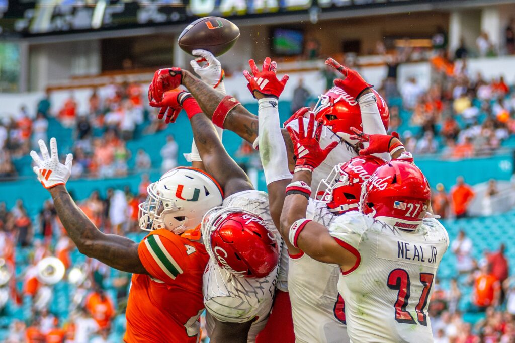 Players reach for the tipped Hail-Mary pass in the final seconds of the fourth quarter of Miami’s game versus Louisville at Hard Rock Stadium on Nov. 18, 2023.