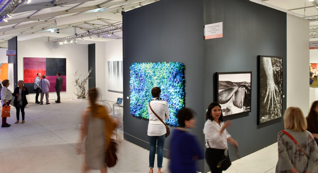 Visitors view artwork on display at the Art Miami fair, one of many art fairs held during Miami Art Week 2023.