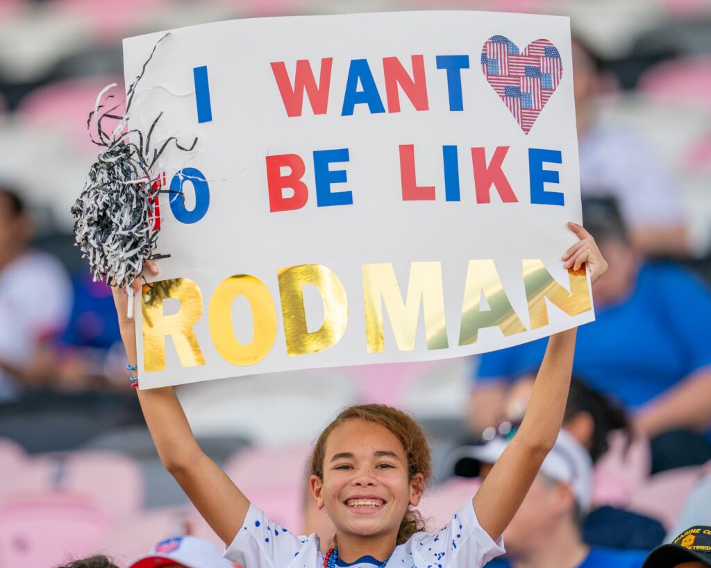 A fan holds up a sign in support of US forward Trinity Rodman ahead of the USWNT match versus China PR at DRV PNK Stadium on Dec. 2, 2023.