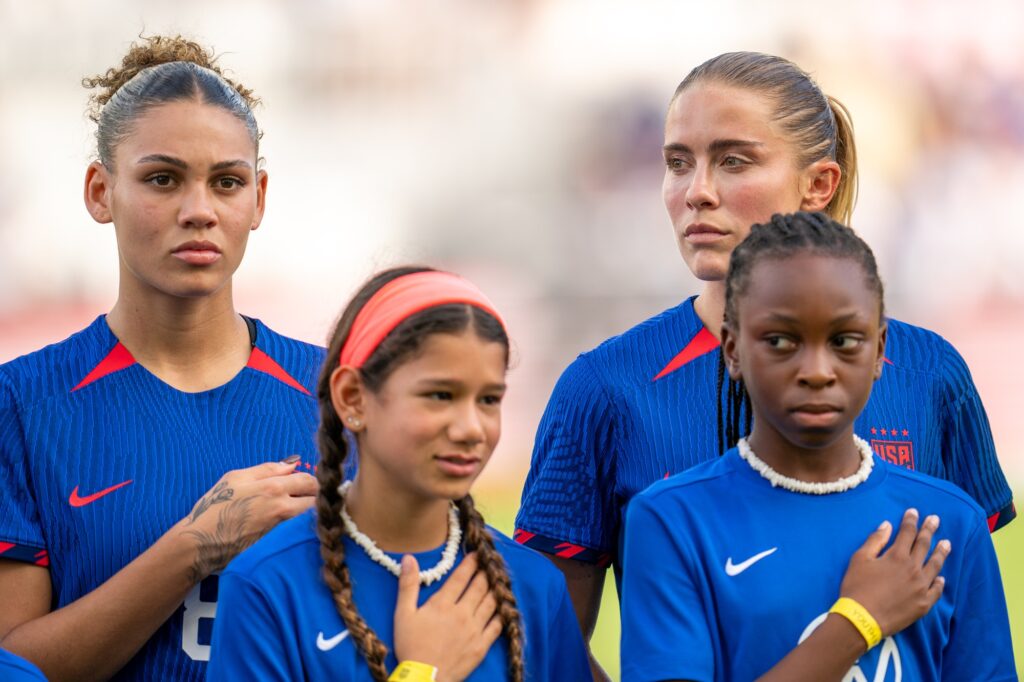Players and mascots stand for the national anthem ahead of the USWNT match versus China PR at DRV PNK Stadium on Dec. 2, 2023.