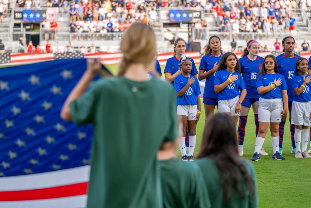 Players and mascots stand for the national anthem ahead of the USWNT match versus China PR at DRV PNK Stadium on Dec. 2, 2023.