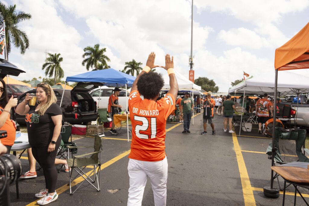 Simon Howard forms the iconic U at a football tailgate outside the Hard Rock Stadium while filming the music video for his song, “Throw Up The U.”