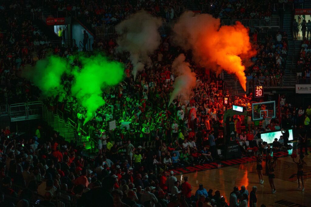 The student section “smoke” is illuminated in orange and green in the first half of Miami’s game versus the University of North Carolina in the Watsco Center on Feb. 10, 2024.