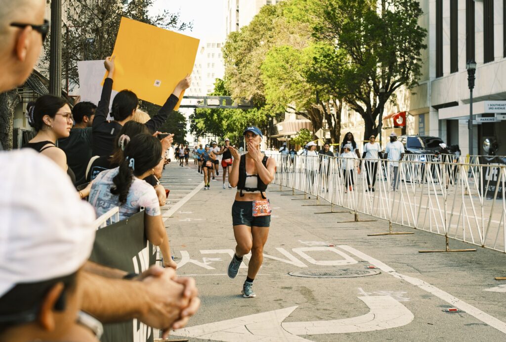 A Miami Marathon participant blows kisses to friends and family as she approaches the finish line on Jan. 28, 2024.
