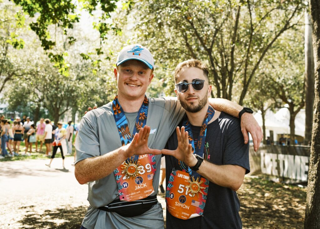Miami juniors Jack Norman and Simon Greenstein stand together and hold up the U after completing the Miami Marathon on Jan. 28, 2024.