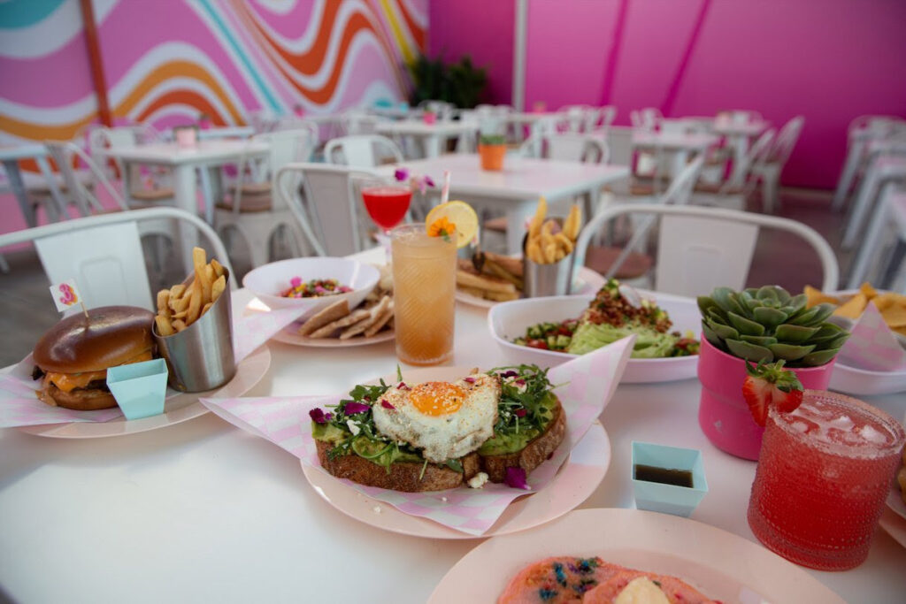 The menu, curated by Chef Becky Brown, includes Barbie-themed options like the Make Waves Avocado Toast and the Beach Burger.