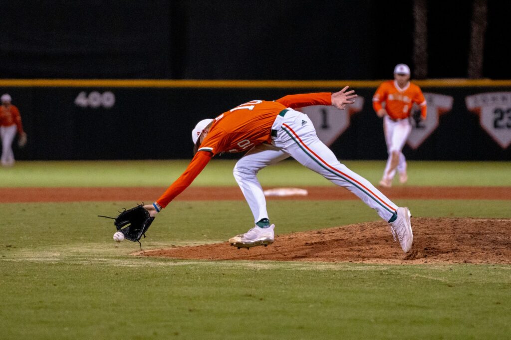 Redshirt sophomore pitcher Brian Walters stretches to secure a ground ball in Miami’s game versus Clemson University at Mark Light Field on March 29, 2024.