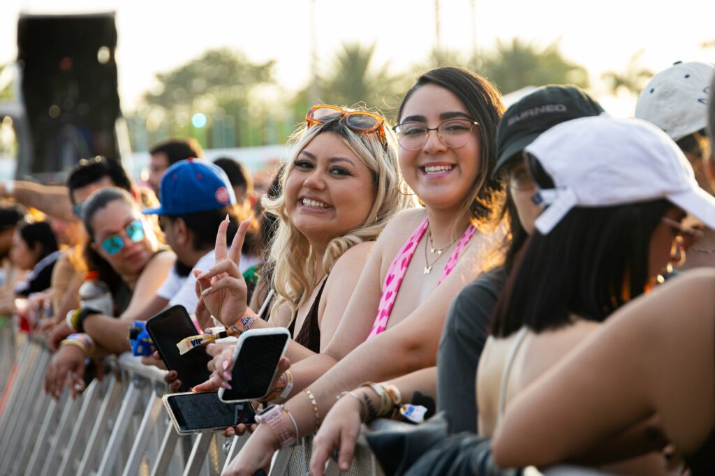 Two women lean on the VIP stage bars to watch the Vibra Urbana Festival, on Saturday, Feb. 17, 2024.