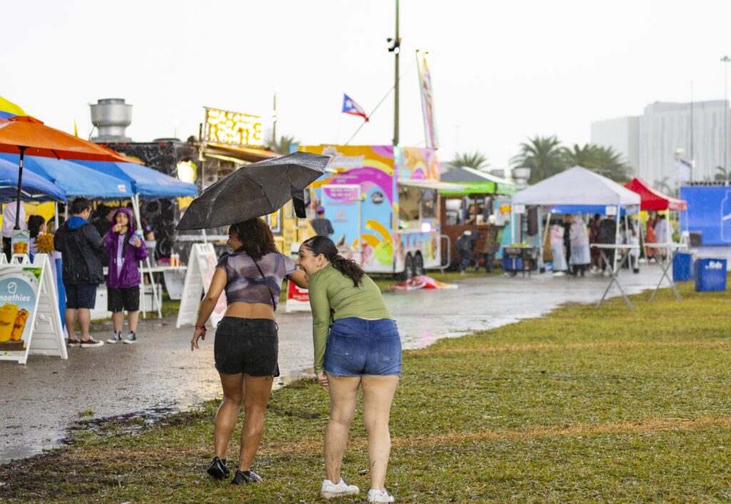 Vibra Urbana attendees brave the rainstorms that ultimately lead to evacuation and performance delays on Sunday, Feb. 18, 2024, at the Miami-Dade County Fair and Exposition Center.