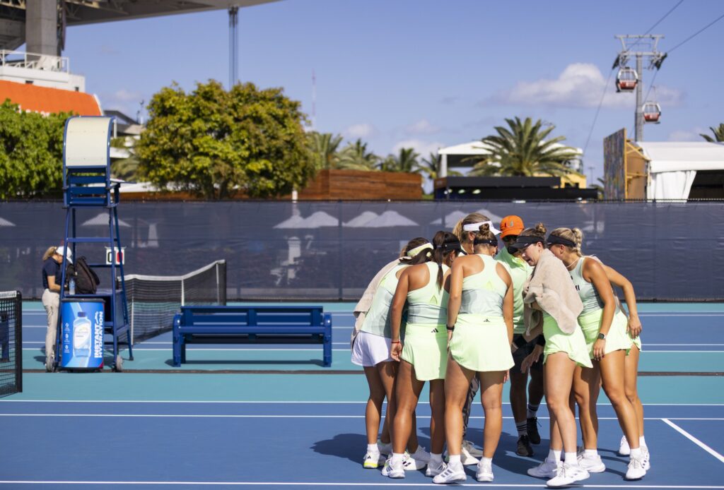 The Miami women's tennis team gathers in a huddle before beginning singles matches against Boston College at the Miami Open at Hard Rock Stadium on March 29, 2024.